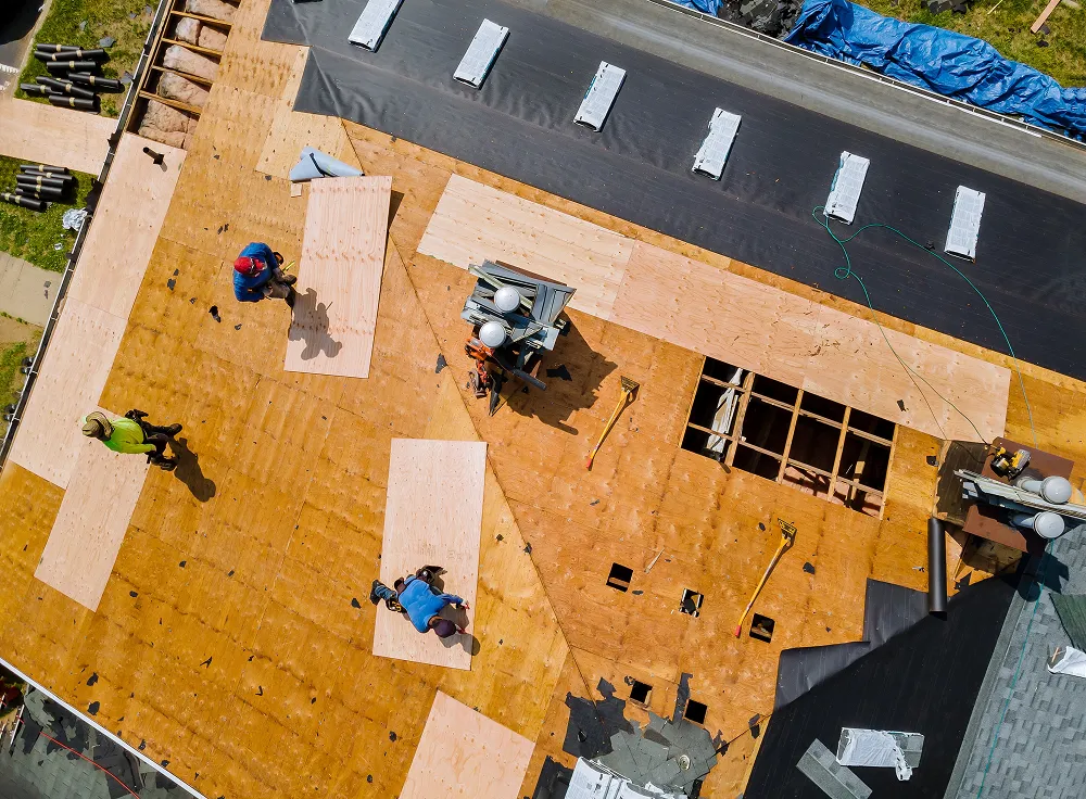 Aerial view of a roof torn back to bare decking with old shingle layers removed